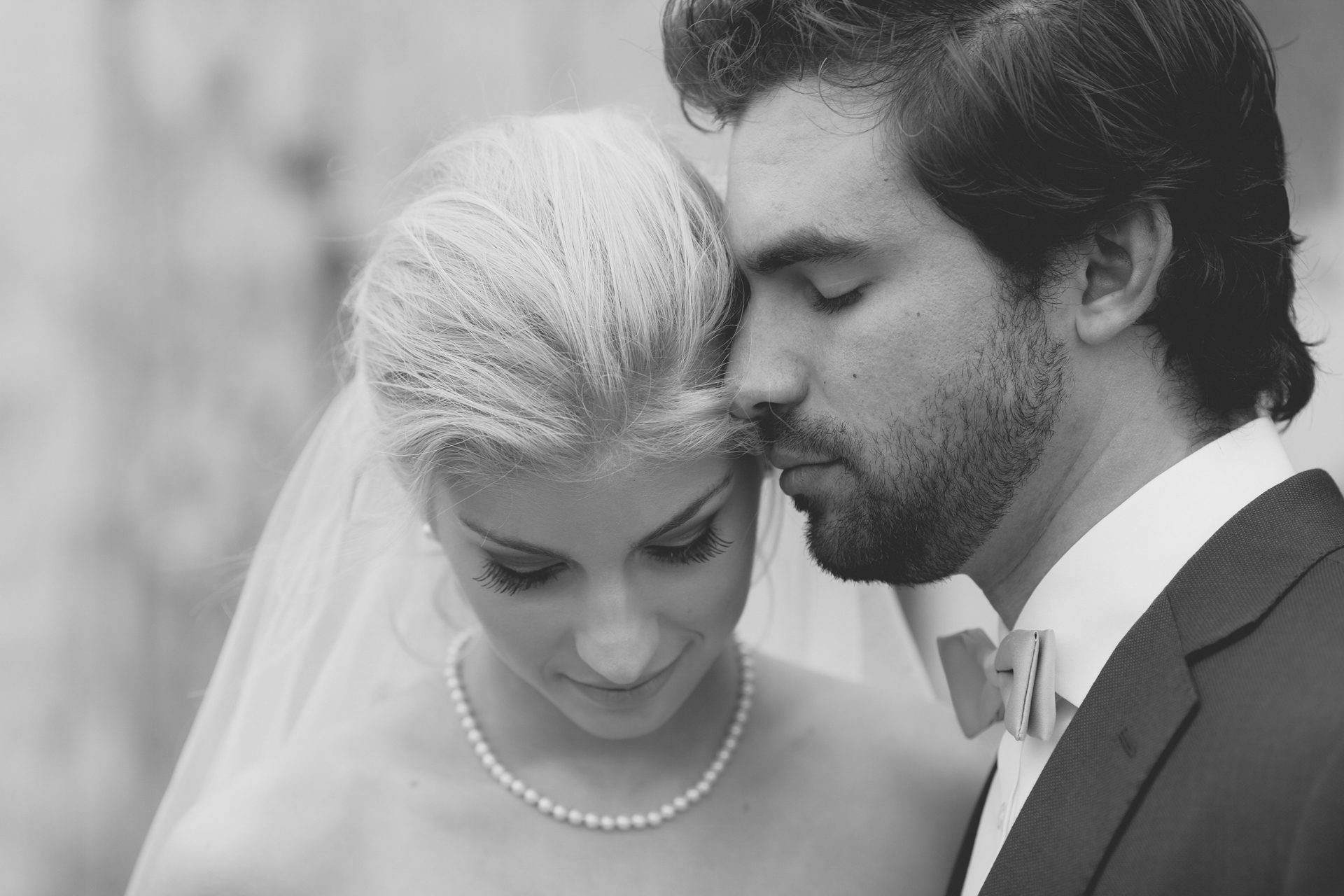 Black and white close portrait of a couple resting forehead to forehead at Sanford Winery