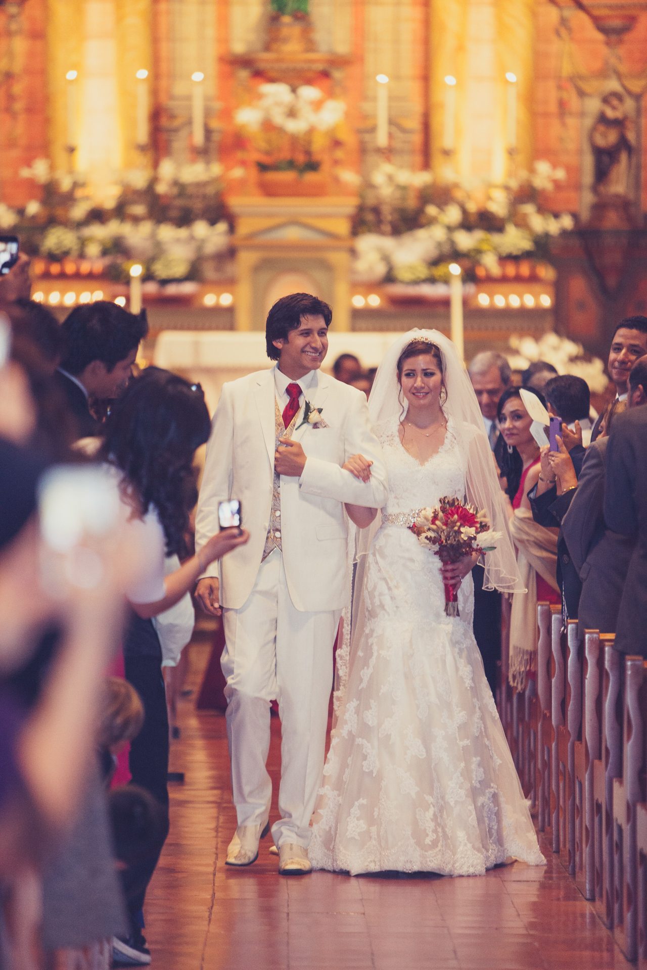 Couple walking arm in arm along a church aisle