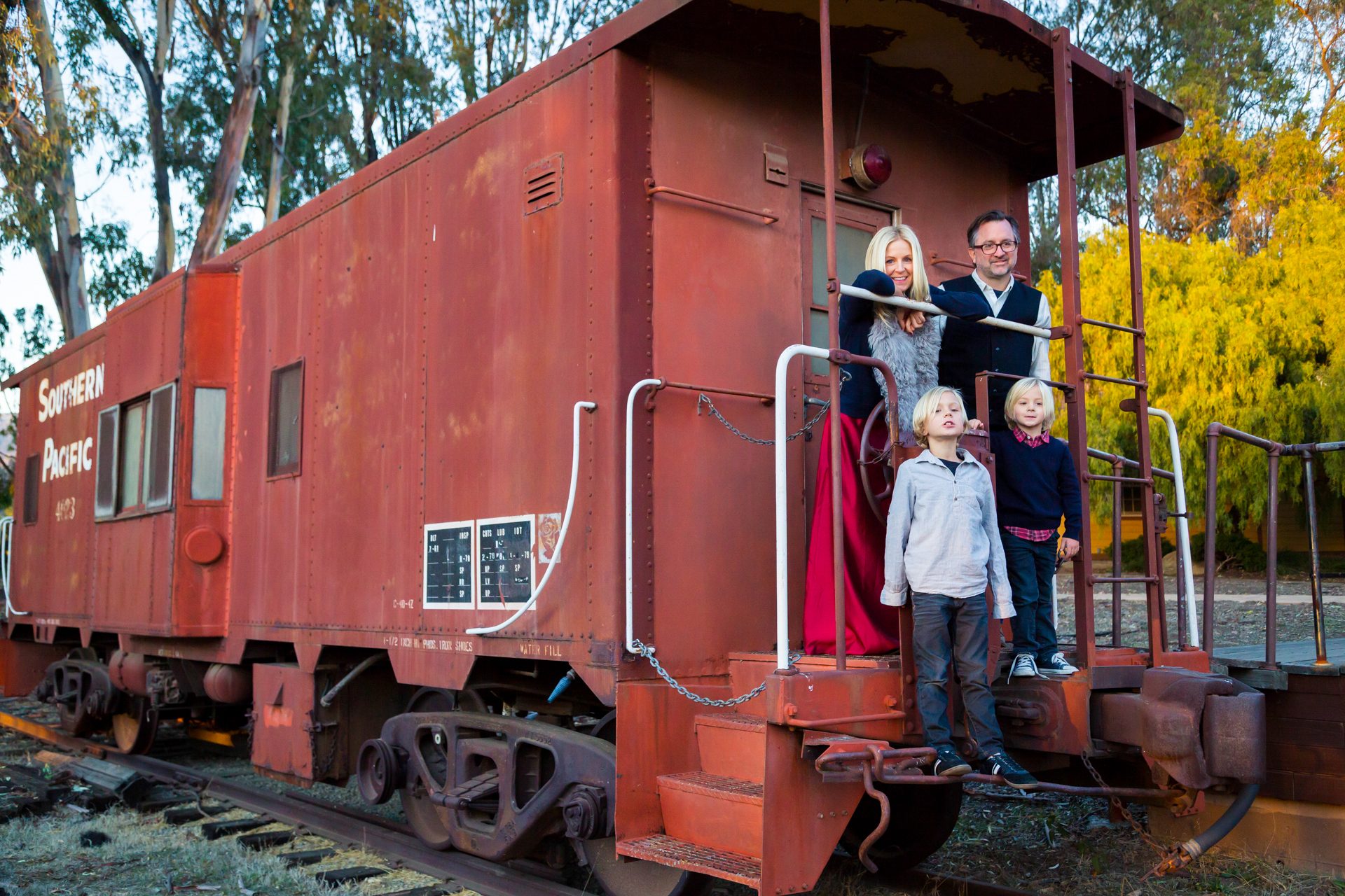 Family gathered on the steps of a red train caboose at Los Carneros in Goleta