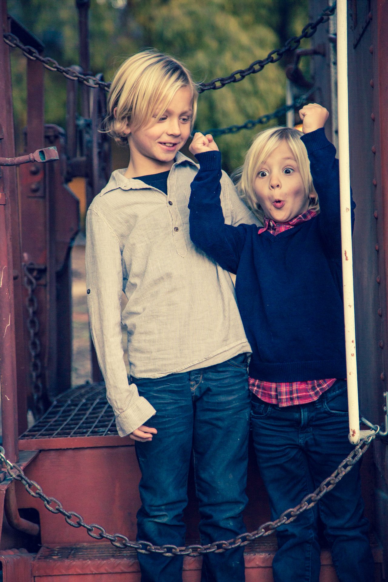 Two young brothers grinning on the platform of a red caboose at Los Carneros in Goleta