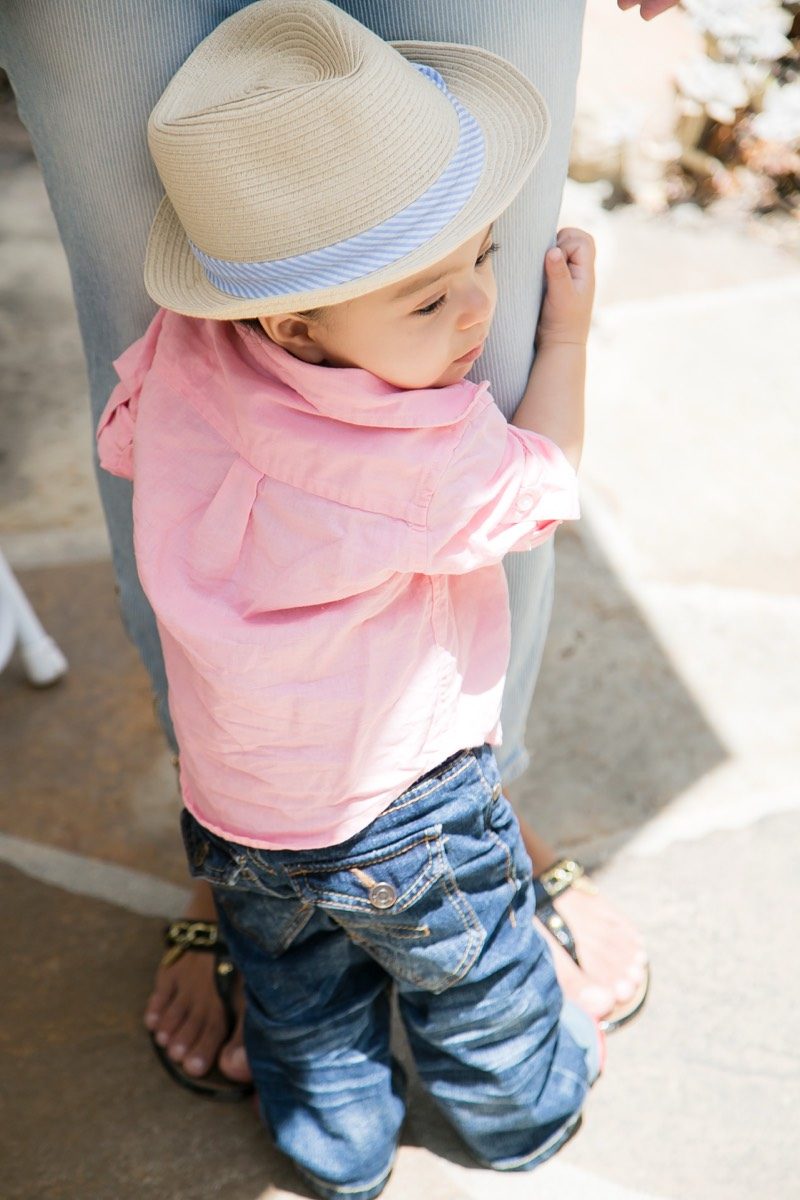 Toddler in a sun hat exploring a garden path