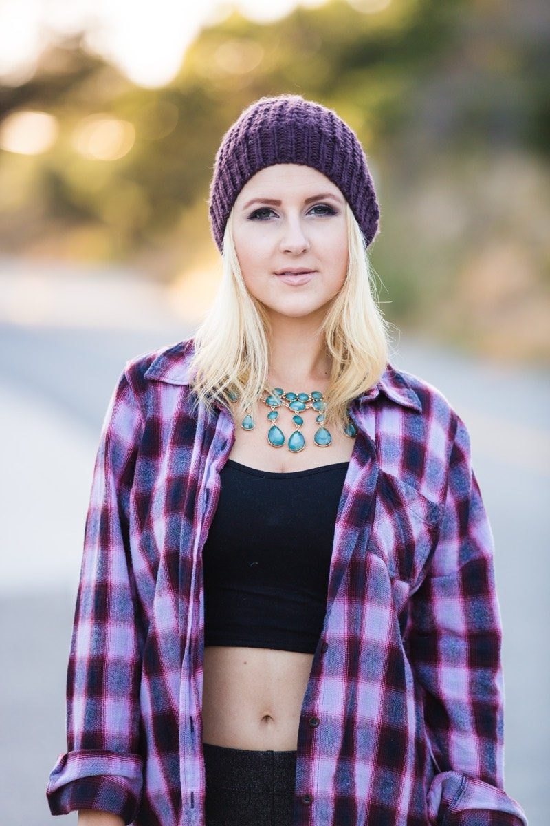 Young woman in a plaid shirt and beanie, outdoors